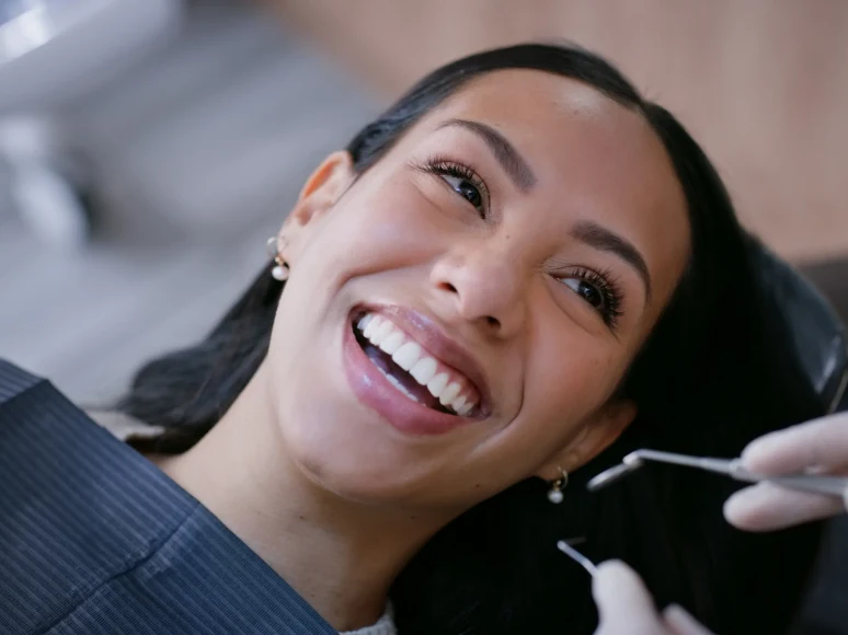A relaxed patient smiling up at her hygienist during a dental visit